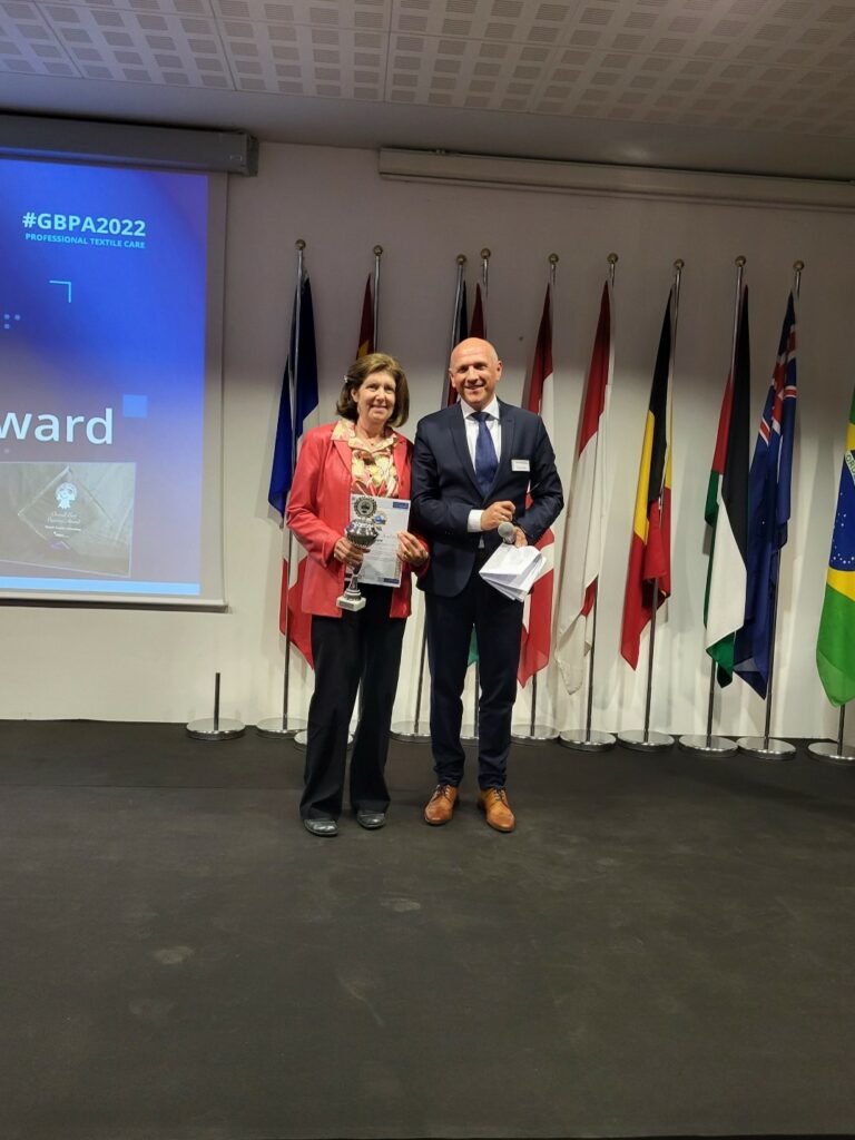 Jan of Jan’s Professional Dry Cleaner USA receives the Best Overall Award RTC-Sme from Mr. Thomas Zeck of Kreussler