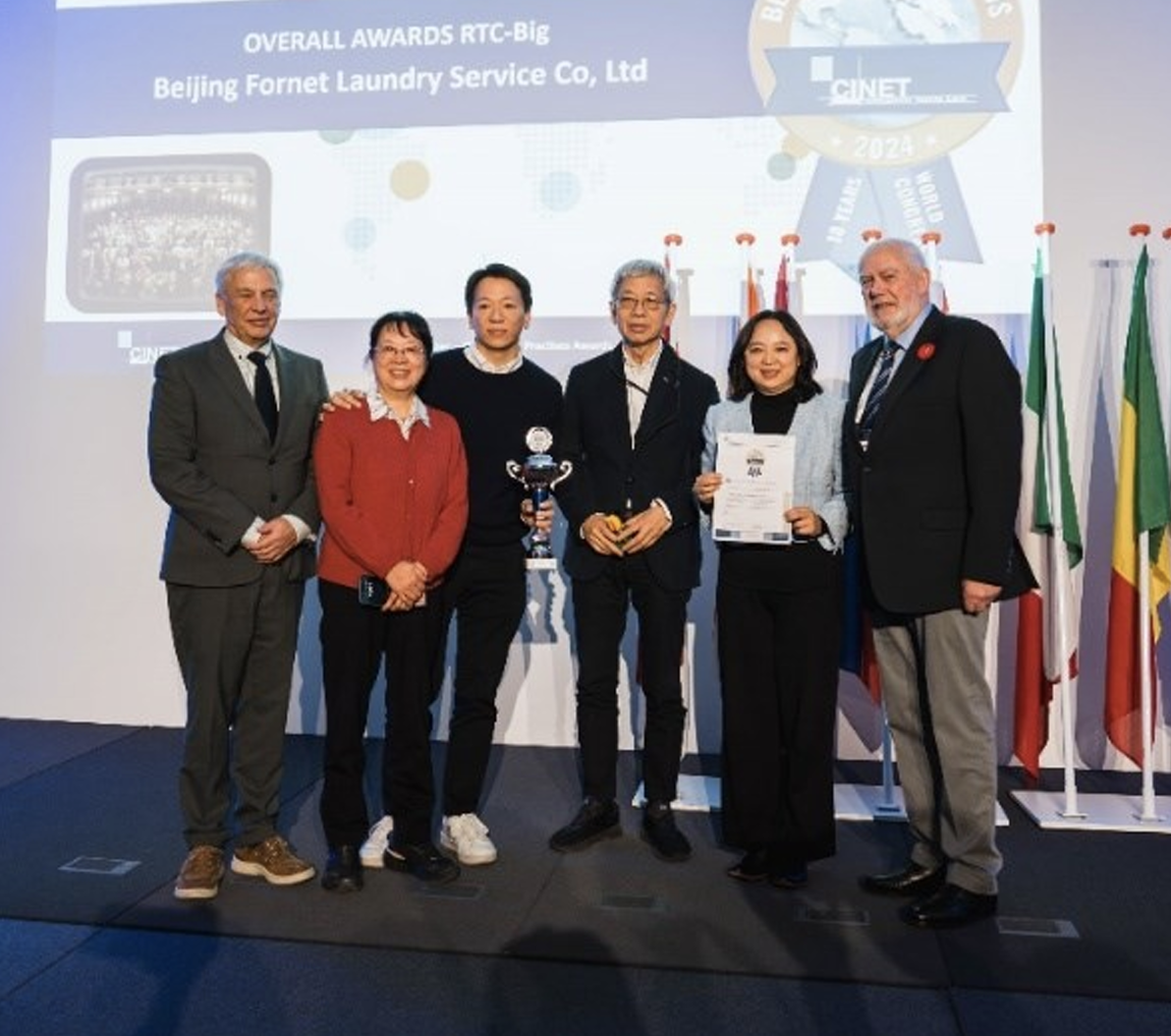 Mr. Peter Wennekes, CEO of CINET, and Mr. Chris Tebbs, Board member CINET, congratulate Mrs. Julie Lijun, together with Mr. & Mrs. Pai Pinchou and Mr. Lei Pai of Beijing Fornet Laundry Service Co. Ltd., China, with their Overall Award 2024, Category RTC-Big.